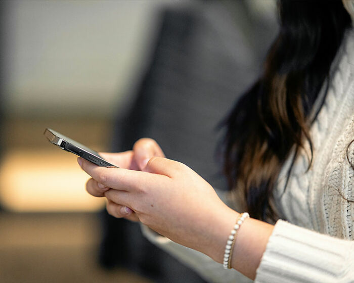 Mulher segurando smartphone, reagindo rapidamente em um encontro, refletindo que comportamento idiota em menos de 2 minutos.