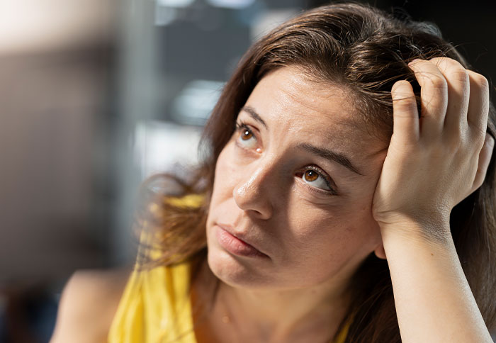 Sad woman reflecting on divorce regret, holding her head with a pensive expression, facing a reality check. Sad woman reflecting on divorce regret, holding her head with a pensive expression, facing a reality check.