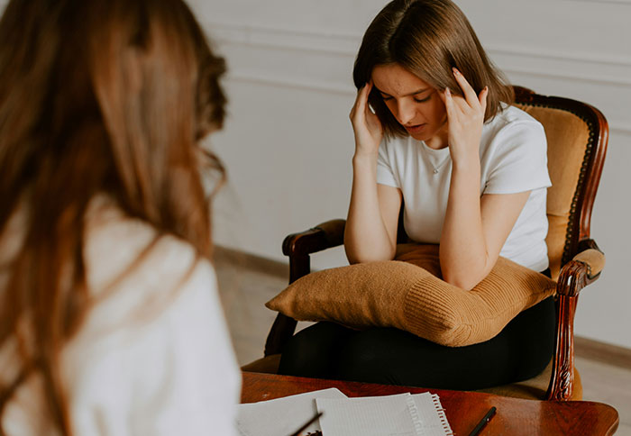 Woman receiving a reality check and reflecting on divorce regret during a counseling session in a cozy room. Woman receiving a reality check and reflecting on divorce regret during a counseling session in a cozy room.