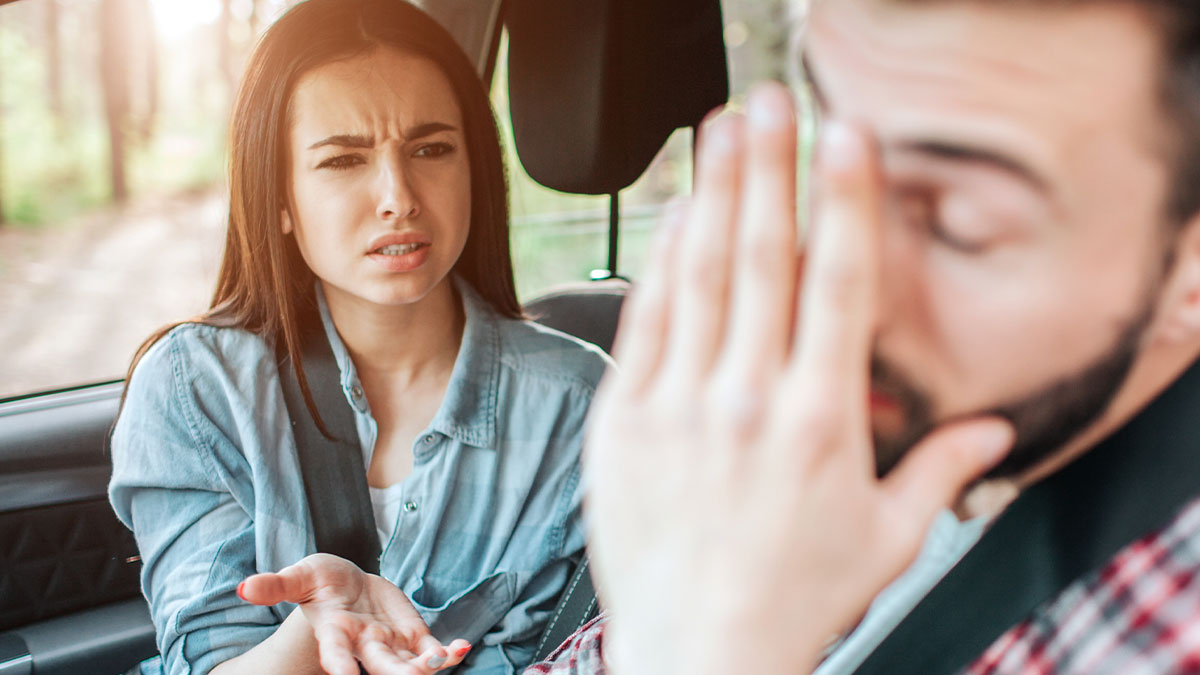 Couple in car with woman looking frustrated and man covering his face, showing hunger and embarrassment emotions.