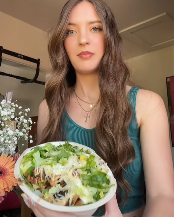 Woman holding Chipotle bowl, testing if more food is given under male names with lettuce and cheese toppings. Woman holding Chipotle bowl, testing if more food is given under male names with lettuce and cheese toppings.