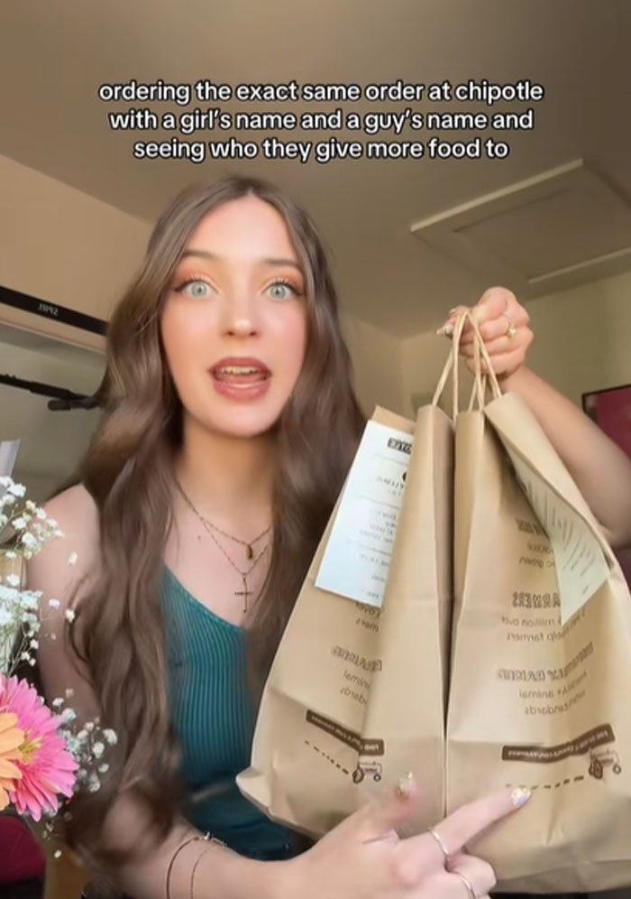 Woman holding multiple Chipotle bags testing if orders with male names get more food than female names Woman holding multiple Chipotle bags testing if orders with male names get more food than female names