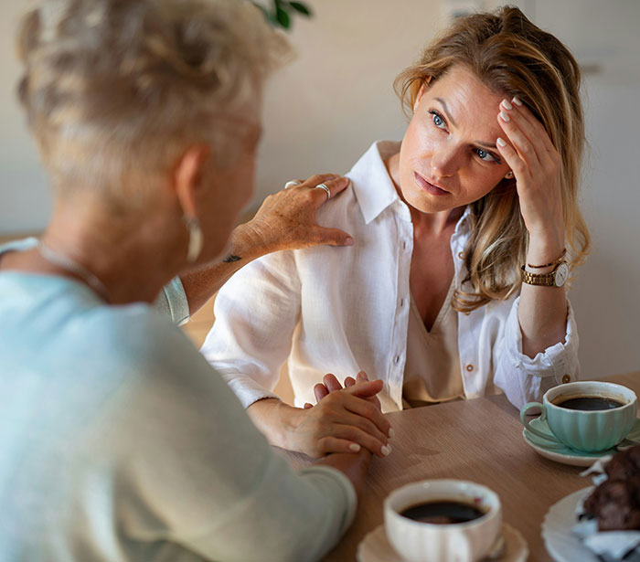 Two women having a serious conversation over coffee, illustrating themes of rude millennial women and generational shifts.