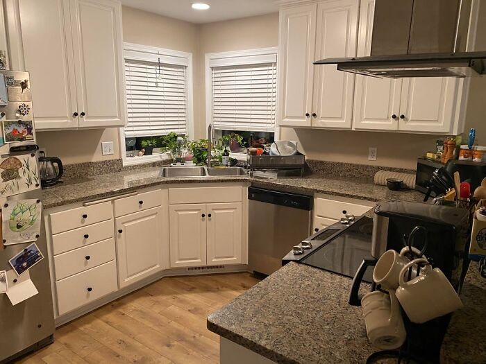 Modern kitchen with white cabinets and granite countertops in a home service professional’s client site.