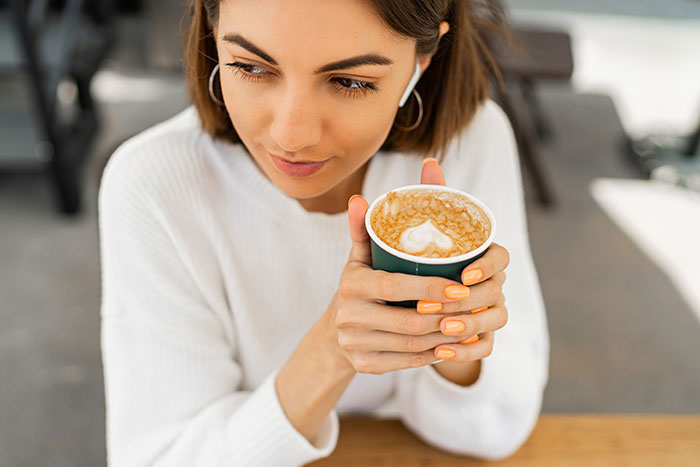 Young woman holding coffee cup with latte art, illustrating a brand mistake that annoyed people and sparked boycott discussions.