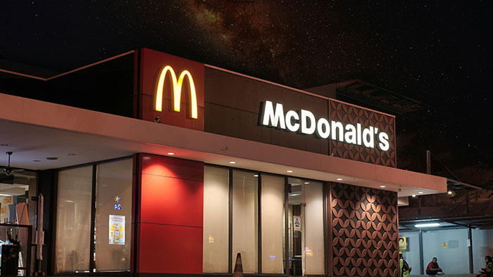 McDonald's building at night with lit signs under a starry sky, illustrating worst gifts people have received concept.