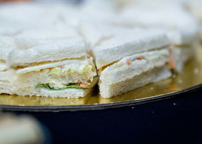Close-up of tea sandwiches on a platter, illustrating casual food often favored by entitled people in 2025 scenarios.