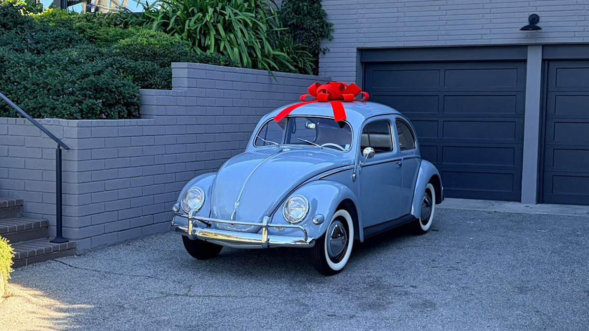 Light blue vintage car with a red bow parked outside a house, symbolizing pure entitlement and unexpected gifts.