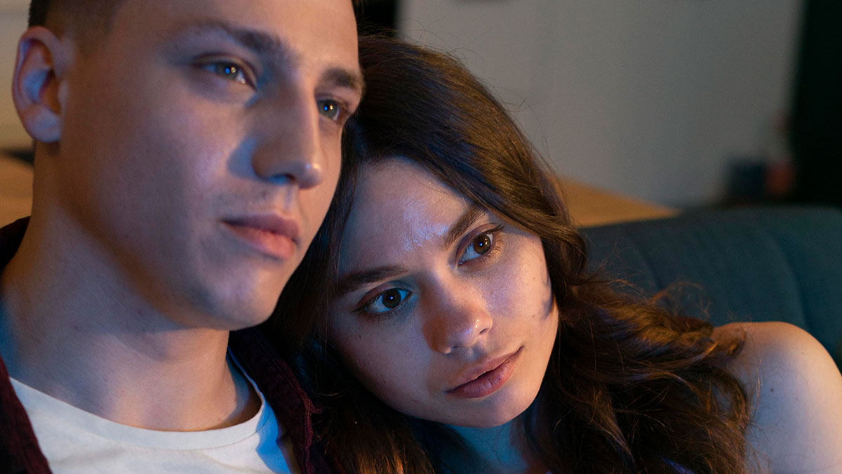 Young couple sitting close together looking thoughtful, illustrating the worst proposal stories that might cause doubt.