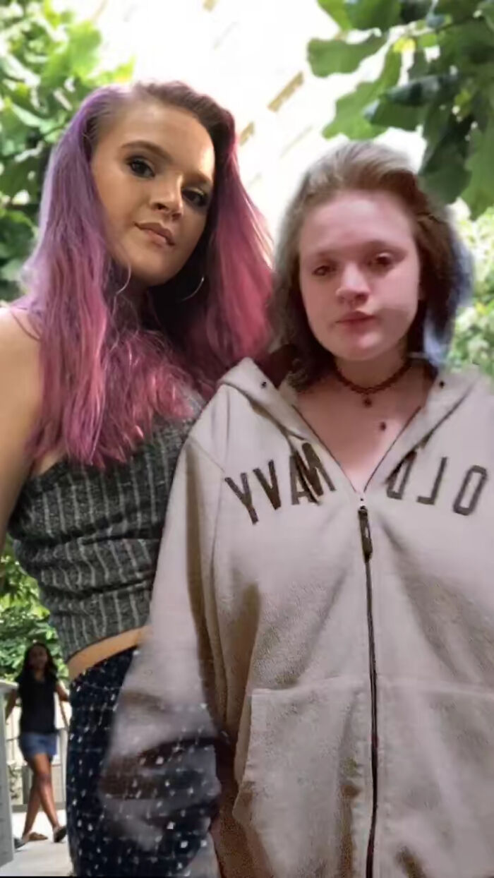Two young women outdoors, one with purple hair and the other in a hoodie, sharing personal stories about glow downs.