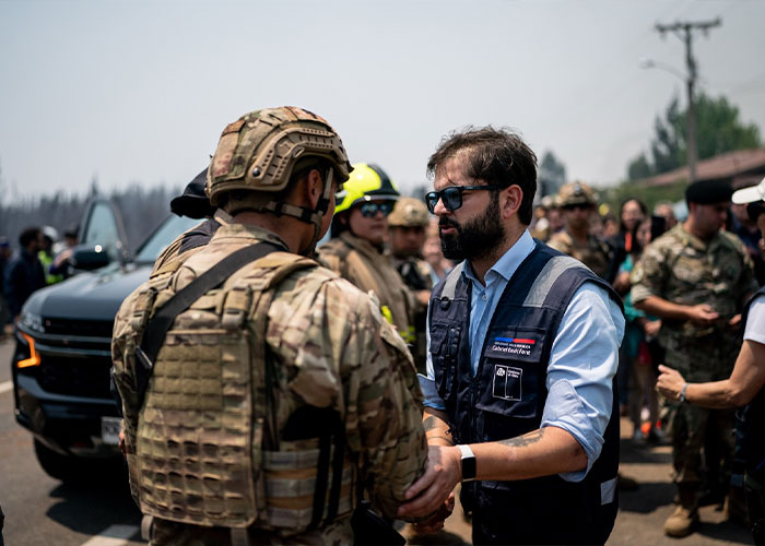 Volunteers and military personnel in a chaotic scene after Chile wildfires destroyed town overnight.