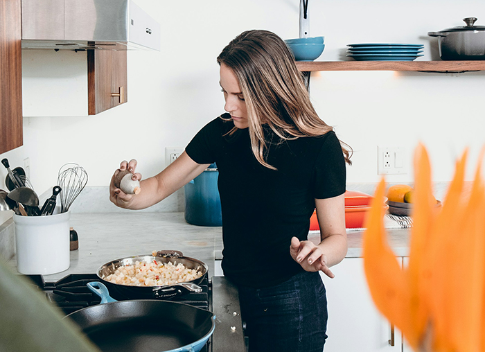 Young woman cooking in a modern kitchen, focusing on preparing food amid concerns about boyfriend fears golddiggers. Young woman cooking in a modern kitchen, focusing on preparing food amid concerns about boyfriend fears golddiggers.