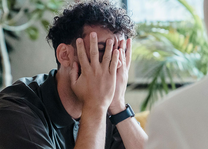 Man covering his face with hands, showing frustration and tantrum after wife refuses to do as he demands. Man covering his face with hands, showing frustration and tantrum after wife refuses to do as he demands.