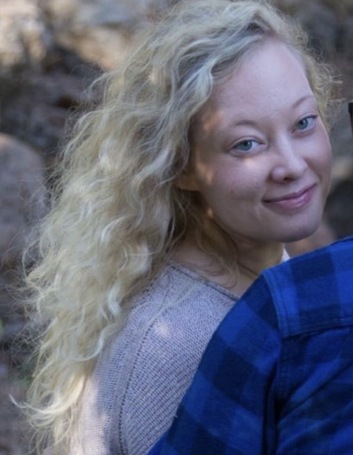 Woman with curly blonde hair smiling softly outdoors, related to Renee Good’s wife breaking silence on fatal ICE incident. Woman with curly blonde hair smiling softly outdoors, related to Renee Good’s wife breaking silence on fatal ICE incident.