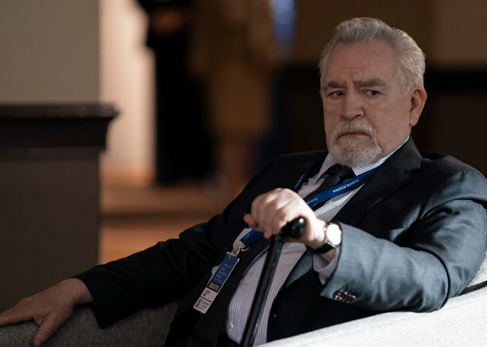 Older man in a suit holding a cane, representing a billionaire forced to change the name of his boat after discovery.