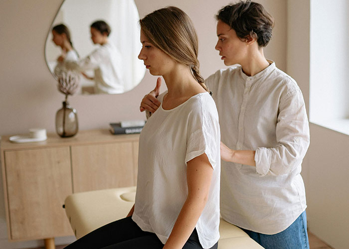 Two women in a calm, minimal room with one assessing the other, illustrating neurodivergent awareness and understanding.