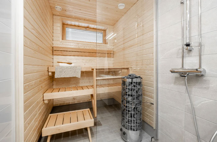 Wooden sauna interior with bench and heater, a unique household item found in few countries worldwide.