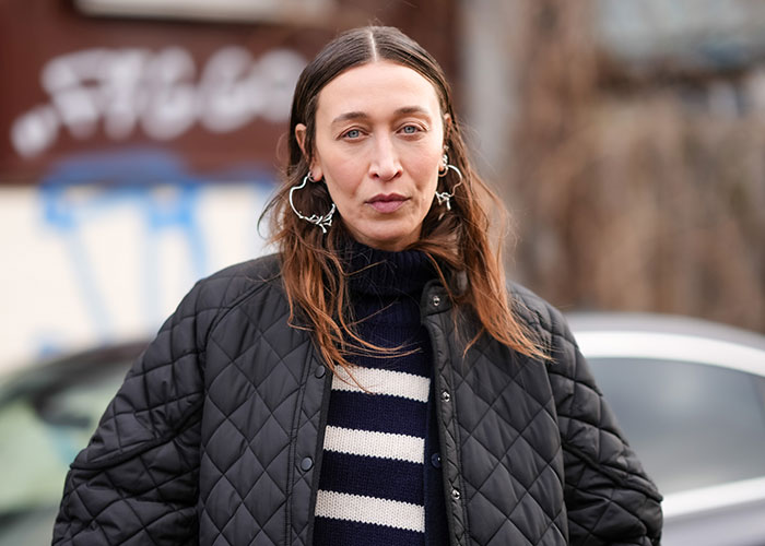 Woman wearing a black quilted jacket and striped sweater, involved in sister of Nicola Peltz's ex story after Brooklyn Beckham rant. Woman wearing a black quilted jacket and striped sweater, involved in sister of Nicola Peltz's ex story after Brooklyn Beckham rant.
