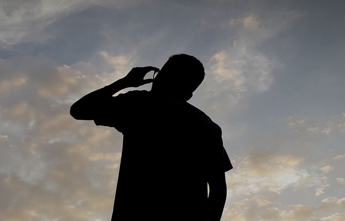 Silhouette of a person appearing thoughtful against a cloudy sky, symbolizing smartness and clever thinking.