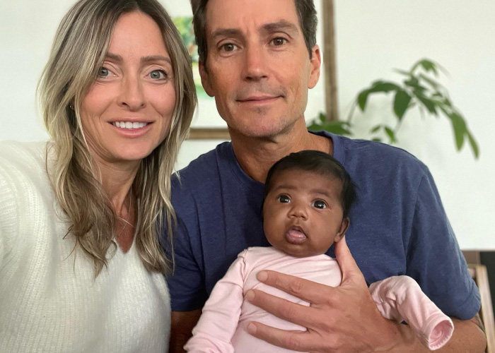Couple holds a baby in their home after a fertility clinic mix-up leads them to deliver another couple's child. Couple holds a baby in their home after a fertility clinic mix-up leads them to deliver another couple's child.