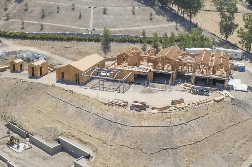 Aerial view of a large celebrity house under construction showcasing lifestyles of the ultra-rich with expansive wooden framing.