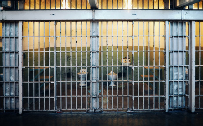 Empty prison cells with metal bars and dim lighting, representing the concept of borderline creepy smart decisions.
