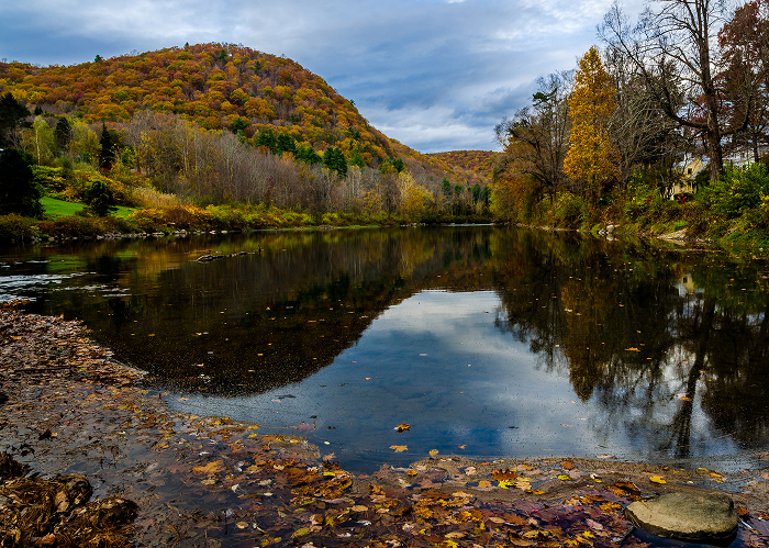 Calm river reflecting autumn trees and hills in one of the most haunted places in America with dark secrets atmosphere. Calm river reflecting autumn trees and hills in one of the most haunted places in America with dark secrets atmosphere.