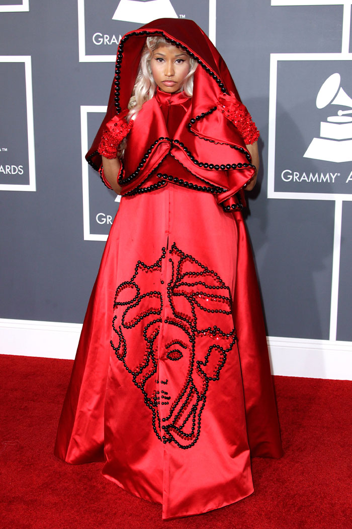 Celebrity in a bold red gown with black beaded design at the Grammys showcasing wild Grammys looks on the red carpet.
