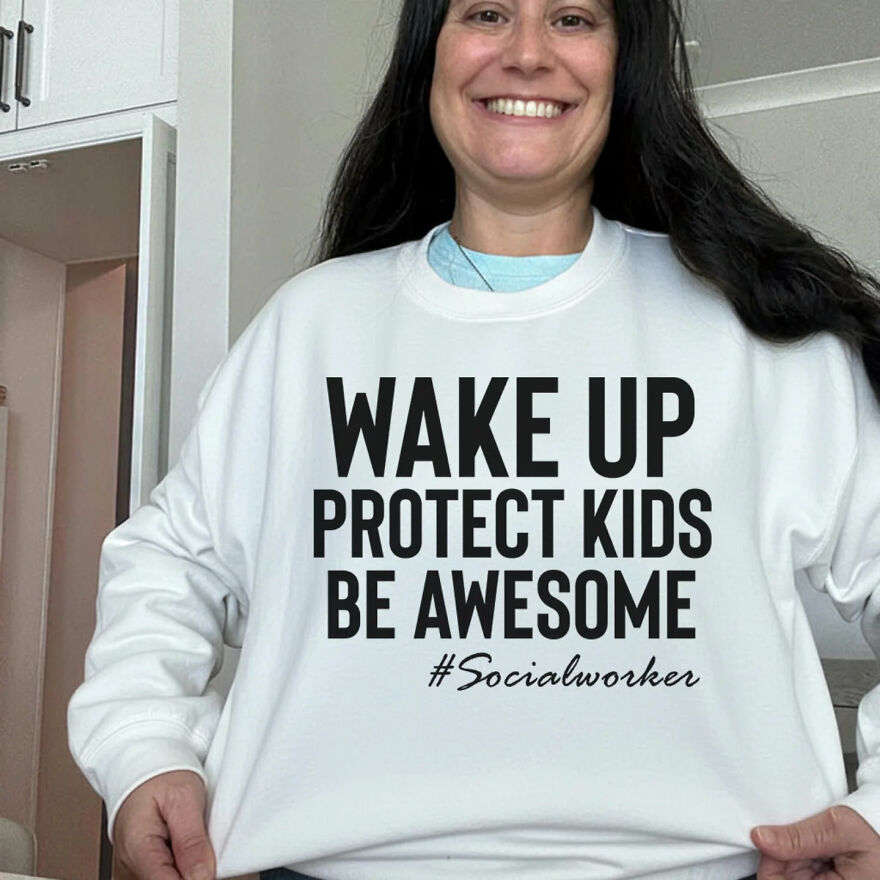 Woman wearing a white sweatshirt with text about protecting kids, highlighting work-life balance disasters in social work jobs.