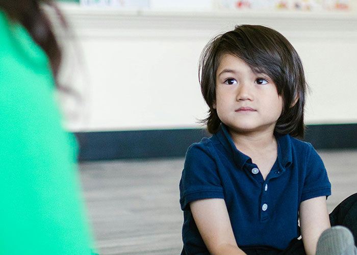 Young boy with no filter sharing family lore in a classroom setting, capturing kids revealing honest stories to teachers.