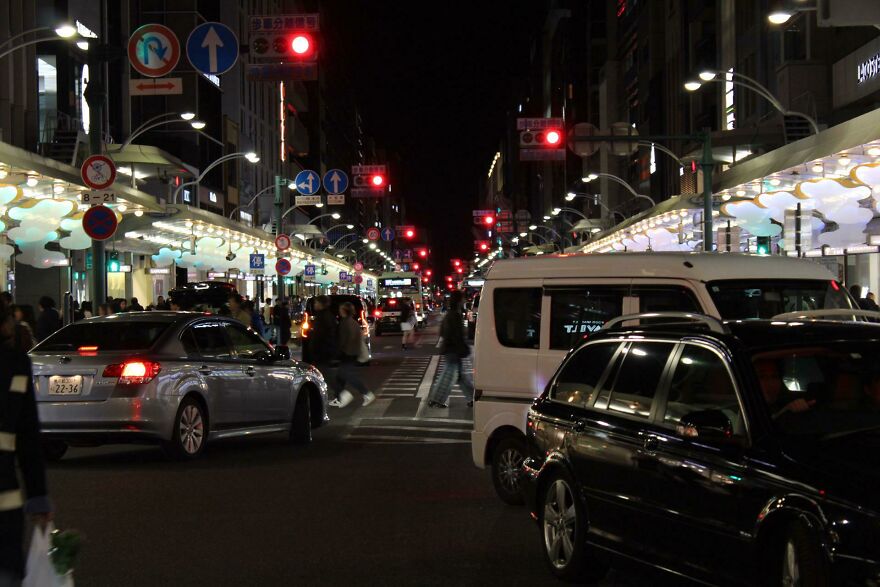 Nighttime city street crowded with cars and pedestrians, illustrating heavy traffic in cities with worst traffic worldwide.