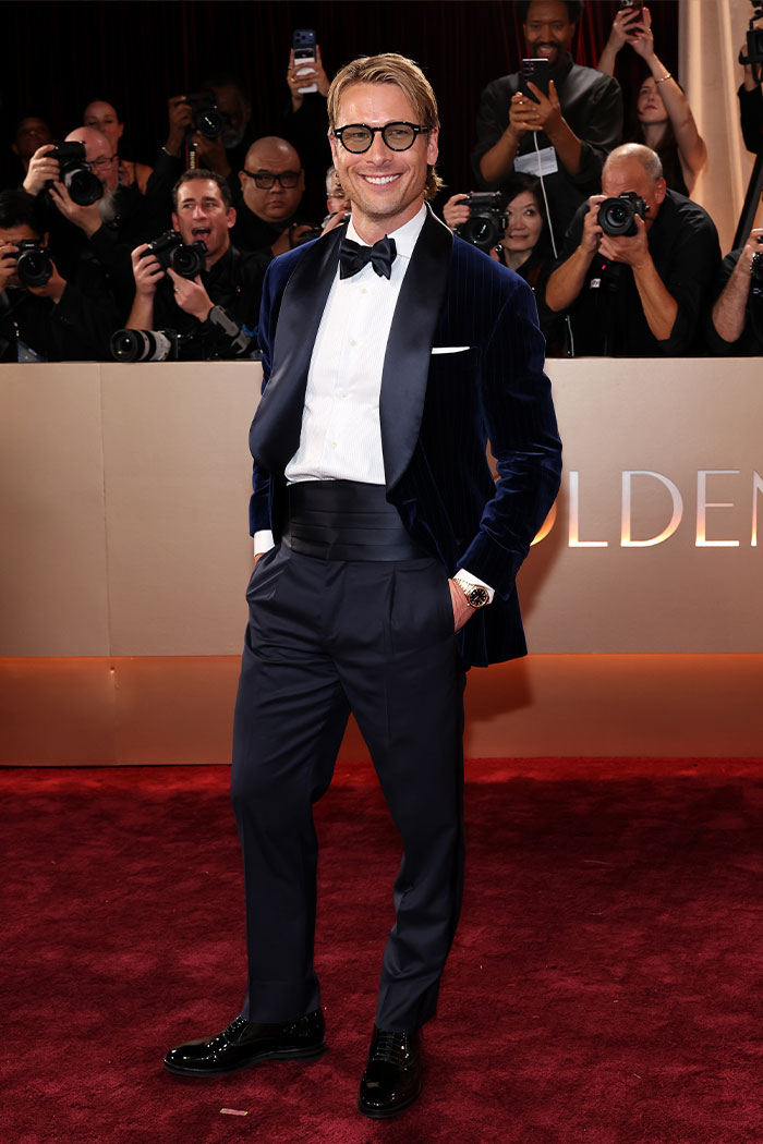 Man in a velvet tuxedo and bow tie on the red carpet showcasing one of the jaw-dropping outfits from the 2026 Golden Globes event.