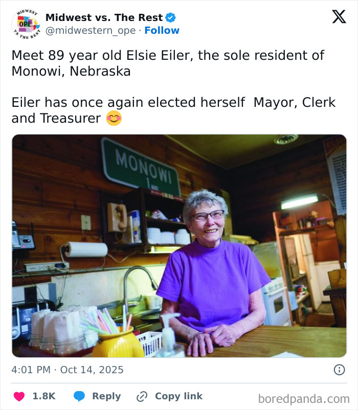 Elderly woman in a purple shirt smiling inside a rustic Midwestern kitchen, highlighting Midwest life and corn culture.