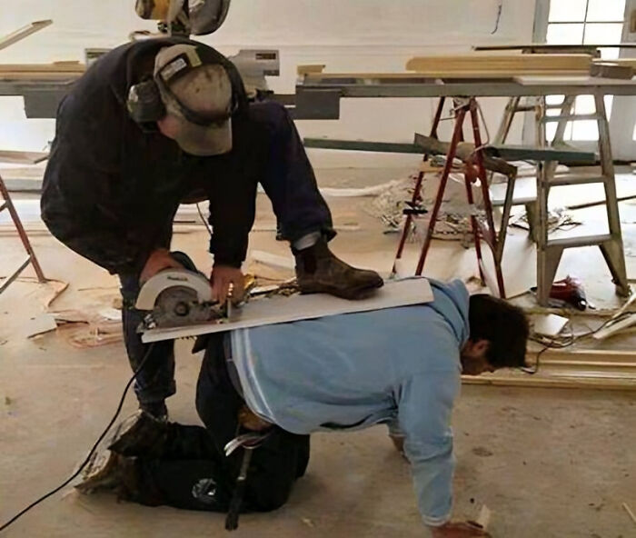 Worker using a circular saw recklessly on coworker’s back, illustrating reckless work moments in a construction site.