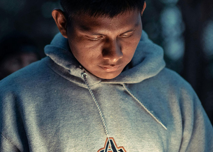 Young man in a hoodie looking down thoughtfully, symbolizing internet troll behavior and online victim impact. Young man in a hoodie looking down thoughtfully, symbolizing internet troll behavior and online victim impact.