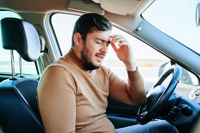 Man sitting in the driver’s seat of a car, holding his head in frustration after an anxiety meltdown risk situation. Man sitting in the driver’s seat of a car, holding his head in frustration after an anxiety meltdown risk situation.