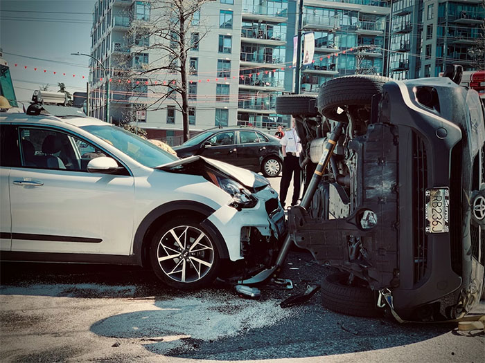 Car crash scene showing a white vehicle front damaged next to an overturned black car after an anxiety meltdown risk. Car crash scene showing a white vehicle front damaged next to an overturned black car after an anxiety meltdown risk.