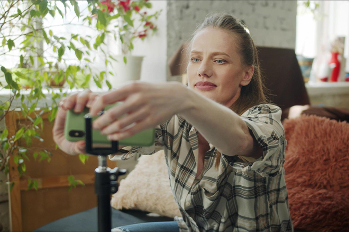 Woman proving husband's family is lying snobs by making a simple switch while recording with her smartphone on a tripod