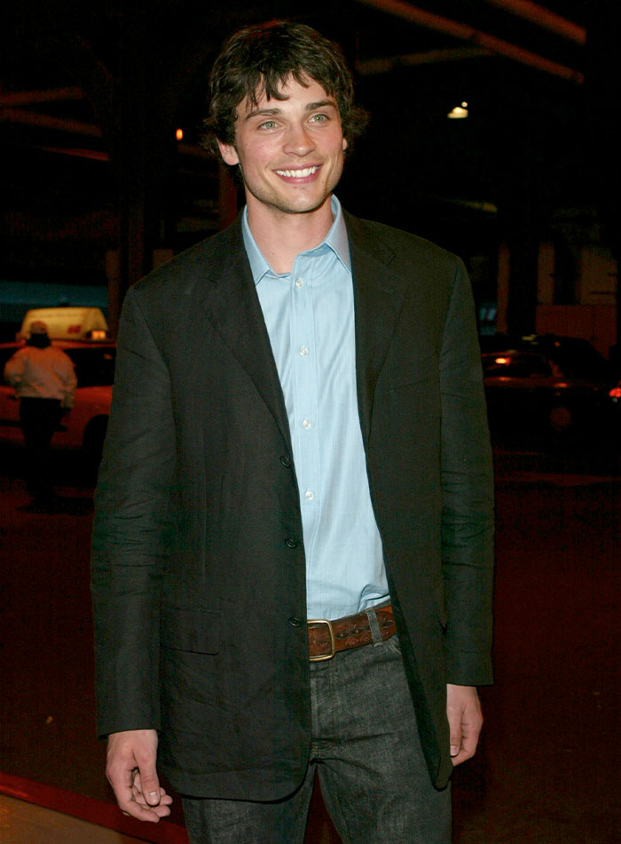 Young 2000s teen heartthrob smiling, wearing black blazer and blue shirt at an evening event outdoors. Young 2000s teen heartthrob smiling, wearing black blazer and blue shirt at an evening event outdoors.
