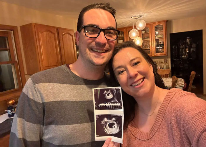 Smiling couple in kitchen holding ultrasound photos and announcing pregnancy, Disney World Smiling couple in kitchen holding ultrasound photos and announcing pregnancy, Disney World