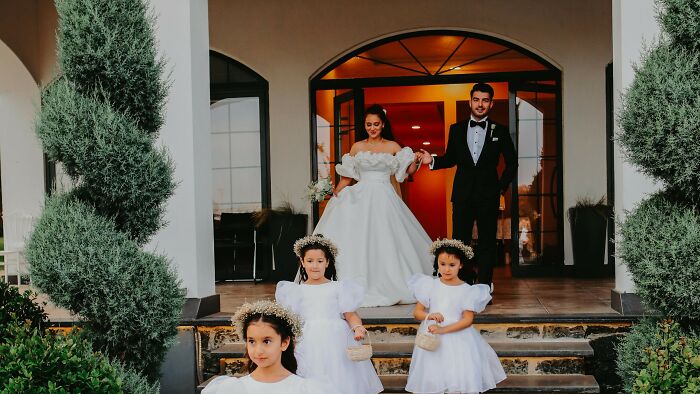 Bride and groom exiting venue with flower girls in white dresses, capturing a moment to cast your vote on right decisions.