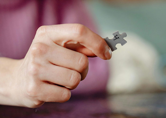 Hand holding a puzzle piece symbolizing wacky stories and unusual experiences shared by people hoping to be believed.