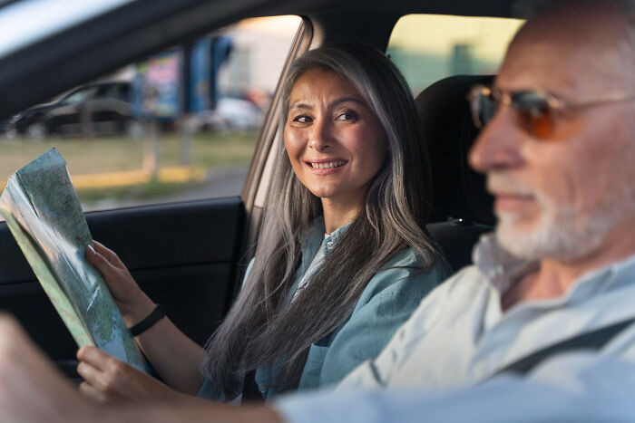 Mom looking shocked and concerned while sitting in a car with an older man, contemplating son's cheating on girlfriend situation. Mom looking shocked and concerned while sitting in a car with an older man, contemplating son's cheating on girlfriend situation.