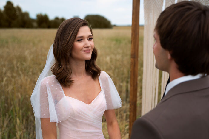 Bride in a white dress and veil standing with groom outdoors, representing one of the fastest times couples said I do