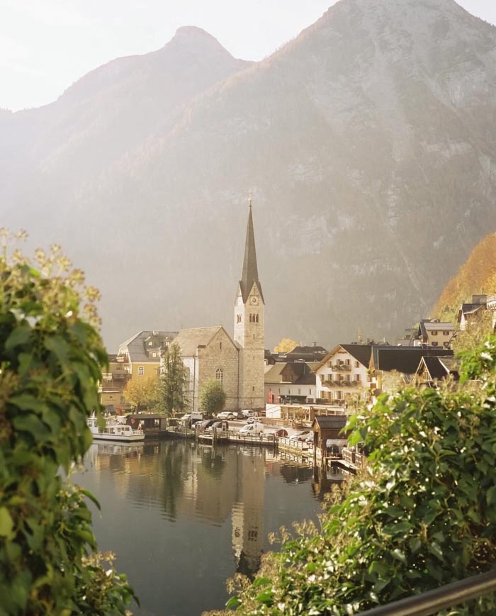 Scenic village reflecting on calm water, representing countries that sleep the most according to OECD time use data.