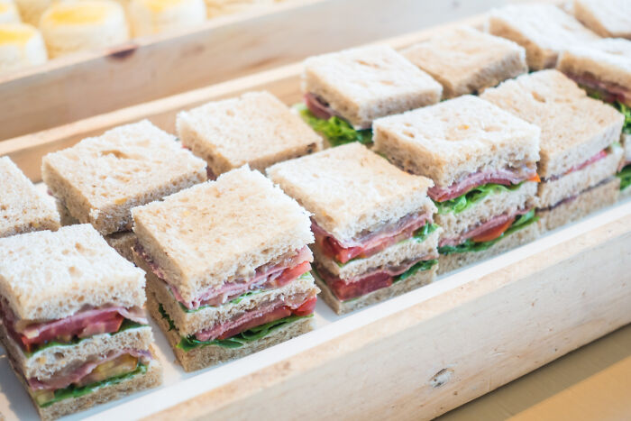 Tray of small club sandwiches neatly arranged, perfect for weird iconic satisfying situations where people said not my problem anymore