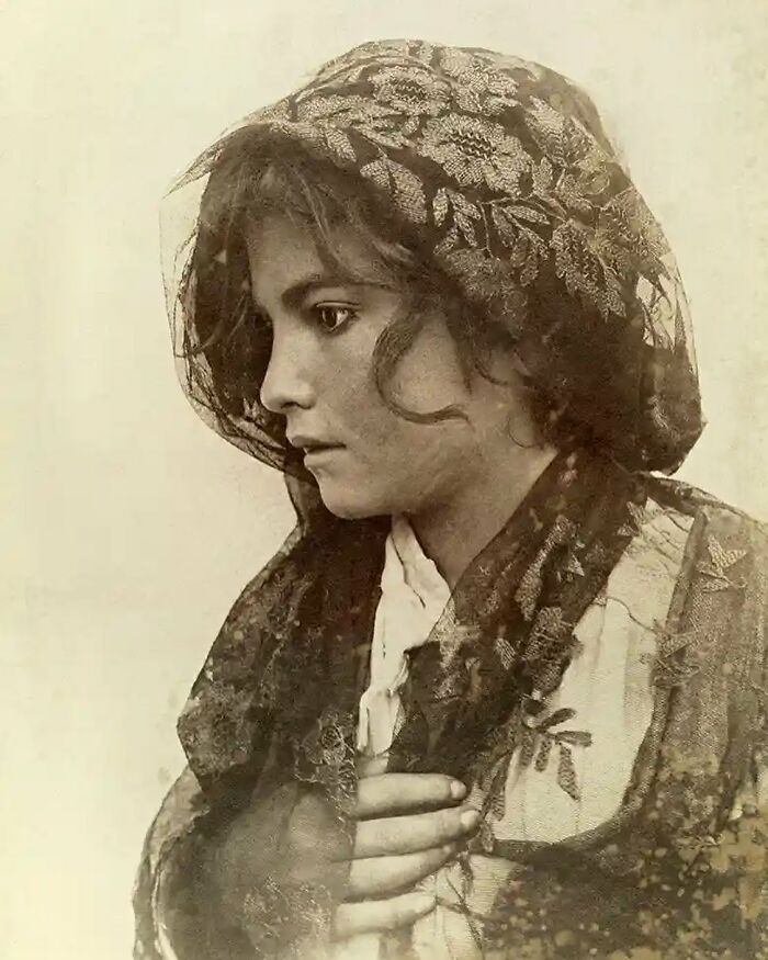 Young woman in vintage lace headscarf, a poignant photograph reflecting the sad and beautiful history of humanity.