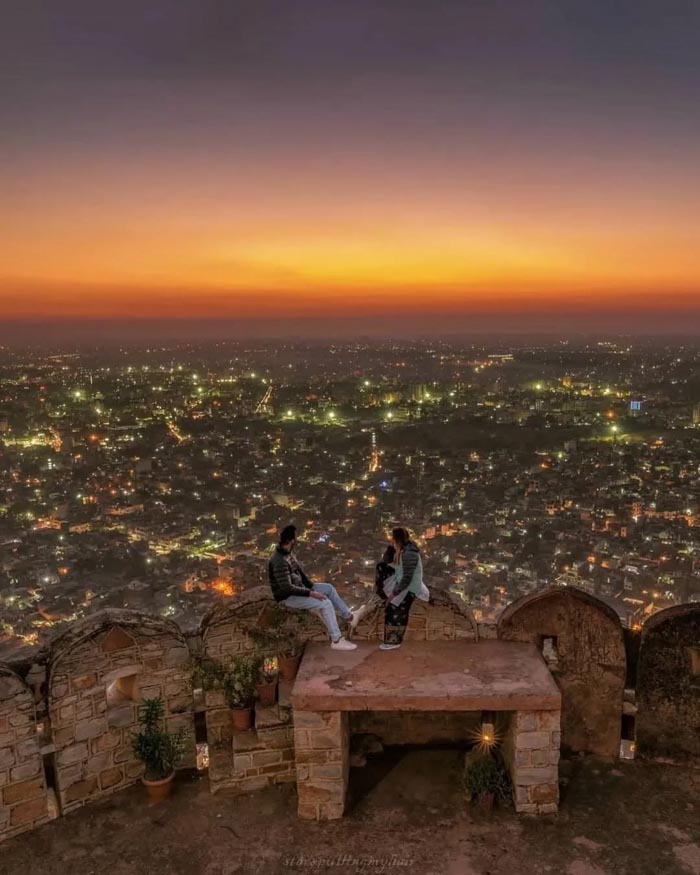 Couple overlooking city lights at dusk representing countries that sleep the most from OECD time use data.