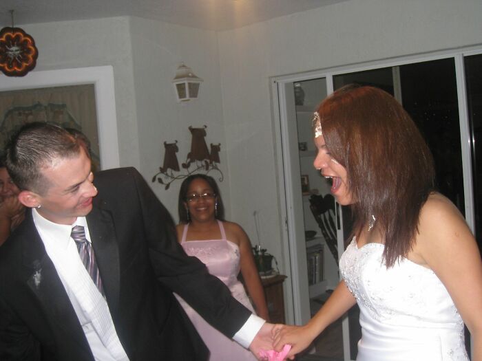 Bride and groom sharing a funny wedding moment with guests in the background, capturing real wedding moments that last.