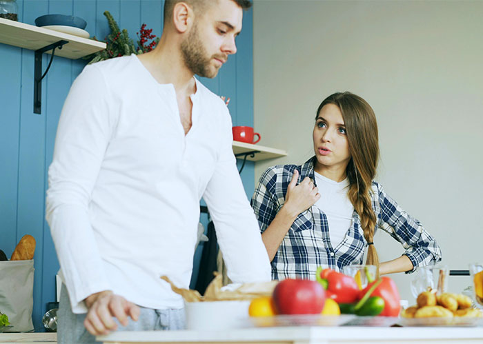 Dad and daughter having a tense conversation in kitchen, highlighting gift disparity between daughter and half-brother at Christmas.